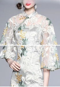 Detail of vintage qipao dress featuring delicate lace layers and floral embroidery