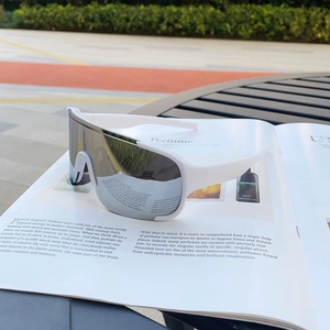 White sports sunglasses with silver mirrored lenses on a magazine in an outdoor setting
