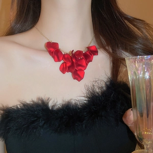 Close-up of red petal tassel necklace on model with elegant gold chain and luxury finish