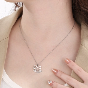 Close-up of a silver rocking horse pendant necklace with zircon accents on a model neck