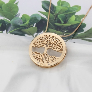 Macro shot of 18k gold plated Tree of Life pendant with VIDA engraving and zircon accents