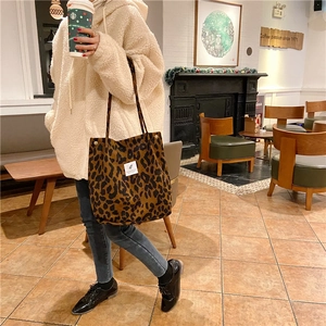 Detalle del bolso tote de pana con estampado de leopardo y etiqueta en una cafetería