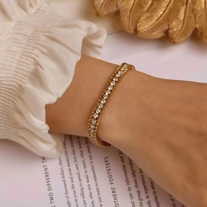 Bracelet tennis chic plaqué or avec zircons cubiques porté sur le poignet