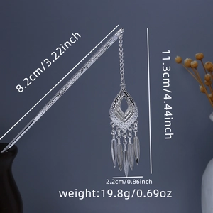 Detailed view of silver Chinese hair pin with hollow diamond pendant and feather tassels
