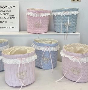 Detail of quilted cotton desktop baskets with lace trim and heart embroidery accents