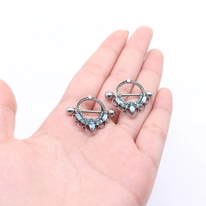 Pair of silver shield nipple rings with light blue crystal teardrop and rhinestones