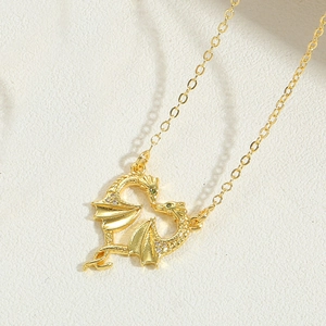 Macro shot of gold dragon heart pendant featuring sparkling diamonds and green gemstone eyes