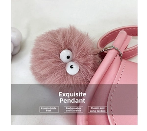 Detail of pink faux fur pom-pom charm with big eyes on mini leather crossbody bag