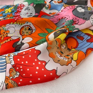 Detail van een kleurrijke zijden sjaal met cartoon dierenprints zoals kat en dino