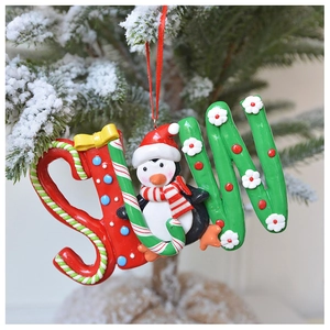 Detailed view of polymer clay SNOW letter ornament with penguin on a snowy Christmas tree