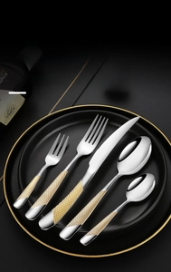 Detailed view of silver and gold starry diamond pattern handles on luxury cutlery set