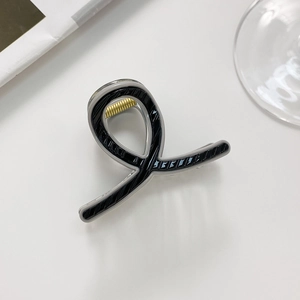 Close-up of black and grey striped hair claw clip with a durable gold metal spring