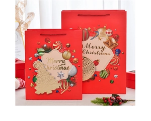 Detailed view of red Christmas gift bags with gold Merry Christmas print and handles