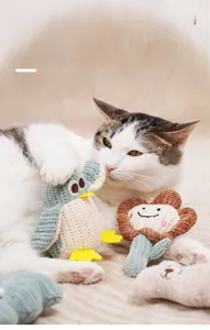 Detailed view of hand-knitted catnip toys in duck and sunflower shapes with a kitten