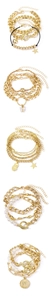 Détail de bracelets multicouches dorés avec perles et divers charms en forme de cœur