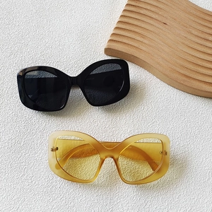Flat lay of elegant cat-eye sunglasses in black and amber with high-quality resin frames