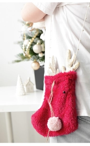 Detail of red plush Christmas elk crossbody bag with golden antlers and bead strap