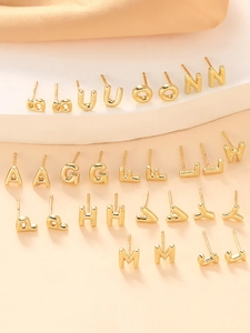 Detailed close-up of polished gold-plated titanium steel alphabet earrings on display