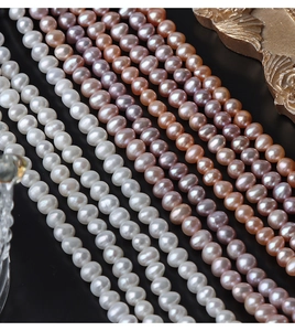 Macro shot of 5mm natural freshwater pearls in white, pink, and lilac on black background