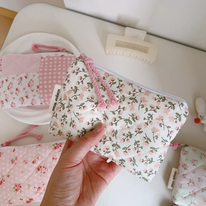 Close-up of pink floral quilted cotton coin purse with simple wish woven label and zipper