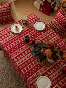 Close-up of red and beige jacquard tablecloth with Christmas reindeer and tree patterns