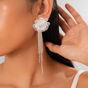 Detail of elegant crystal flower earrings with long shimmering tassel fringe on a model