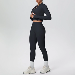 Detail of black three-piece yoga set featuring long sleeve zip jacket with thumb holes