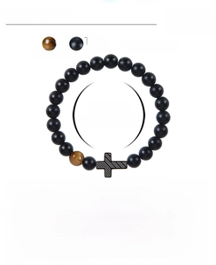 Detailed view of 8mm matte black onyx and tiger eye stone beads with cross charm