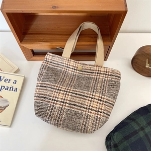 Dettaglio della borsa da pranzo retrò in lana scozzese con trama tweed e bottone dorato