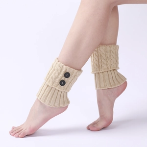 Detailed knit texture and black button accents on beige cable knit leg warmers for women