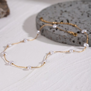 Minimalist gold stainless steel necklace featuring irregular white baroque pearls