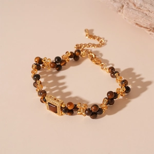 Detailed view of beaded bracelet with tiger eye stones and golden zircon square pendant