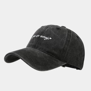 Détail de la broderie 'you are enough' et du cœur sur casquette en coton noir délavé