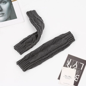 Macro detail of dark grey knit arm warmers featuring a vintage thick diamond cable pattern