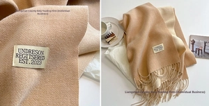 Detailed view of camel cashmere-feel scarf with twill weave texture and long tassels