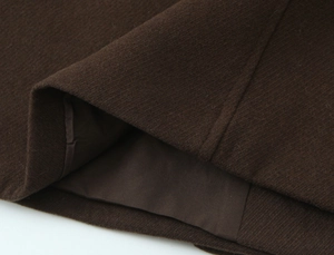 Detailed close-up of dark brown wool blend fabric texture with smooth inner lining