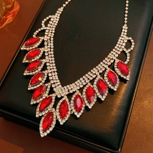 Detailed macro view of gold necklace with red leaf crystals in luxury jewelry gift box