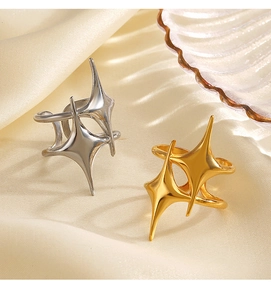 Close-up of gold and silver star-shaped stainless steel rings on yellow satin fabric