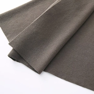 Macro shot of dark brown knit fabric showing soft texture and detailed weave patterns
