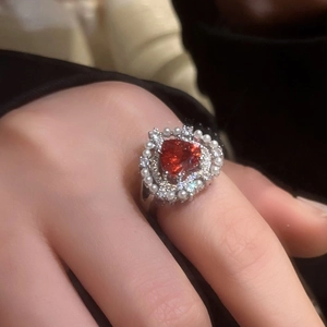 Detail of heart-shaped red ruby ring with double layers of pearls and zircons