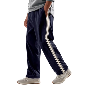 Detail of blue corduroy track pants showing vertical texture and side stripe trim
