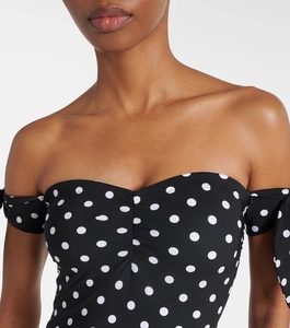 Close-up of black polka dot off-the-shoulder swimsuit with elegant bow tie sleeve details