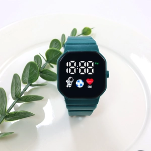 Deep green digital LED watch with octagonal case and astronaut icon on white ceramic tray