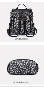 Detail view of anti-theft back pocket and oval bottom of white leopard print backpack