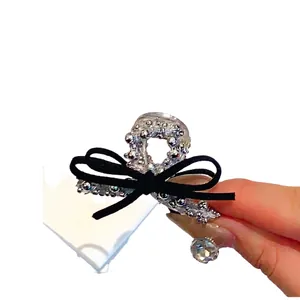 Mini pince à cheveux argentée avec nœud en velours noir et pendentif en cristal brillant