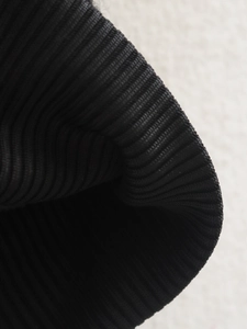 Close-up of the black ribbed knit fabric and texture on the bomber jacket cuff