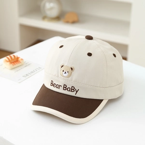 Close-up of Bear Baby embroidery on a beige and brown cotton toddler baseball cap