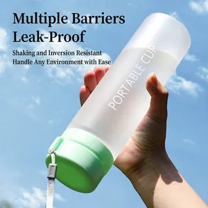 Frosted mint green portable plastic water bottle with handle against a blue sky background