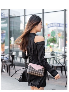 Piccola borsa a tracolla rosa e marrone con motivi a cerchio indossata da una modella