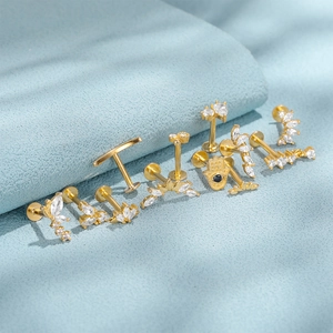 Detail of gold S925 sterling silver labret studs with zircon leaf and Hamsa hand designs